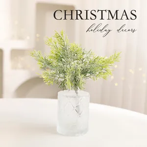 Artificial frosted pine branch in textured glass vase for Christmas holiday decor