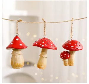 Detailed view of three red spotted mushroom ornaments hanging on a rustic twine string
