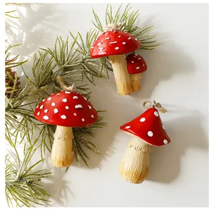 Detailed view of red and white spotted mushroom Christmas ornaments on pine branch