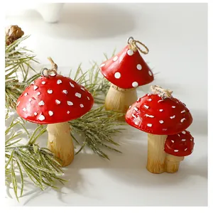 Close-up detail of red and white spotted mushroom ornaments with natural twine hanging loops