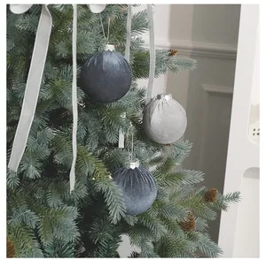 Detailansicht eleganter beflockter Samt-Weihnachtskugeln an einem festlichen Tannenbaum