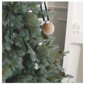 Detailansicht eleganter grüner und goldener Samt-Weihnachtskugeln am Weihnachtsbaum
