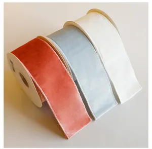 Primer plano de cintas de terciopelo terracota, azul claro y crema para manualidades navideñas