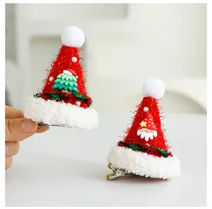 Set di due mini mollette per capelli a cappello di Babbo Natale con decori.