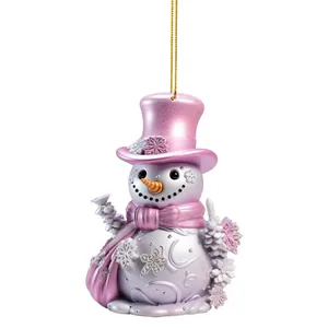 Adorno navideño de muñeco de nieve en acrílico rosa con detalles de copos y cordón dorado.