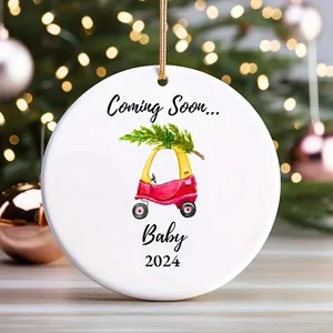 Nahaufnahme eines weißen runden Weihnachtsschmucks mit Coming Soon Baby 2024 Text