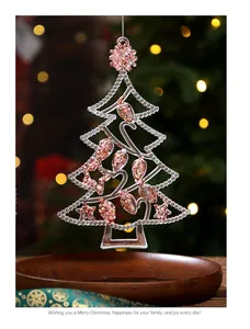 Close-up of a transparent acrylic Christmas tree ornament with rose gold glitter details.