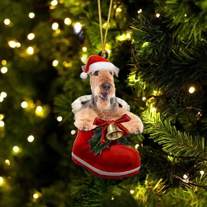 Χριστουγεννιάτικο στολίδι σκύλου Airedale Terrier σε κόκκινη μπότα στο δέντρο
