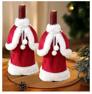 Close-up of red velvet Christmas wine bottle covers with white fur trim and bows.