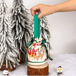Sacchetto regalo di Natale in tela con stampa di Babbo Natale tenuto in una scena festiva.