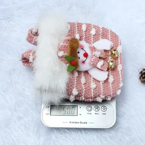 Handgemaakte roze pluche kerstzak met sneeuwpop decoratie die 50g weegt op een schaal