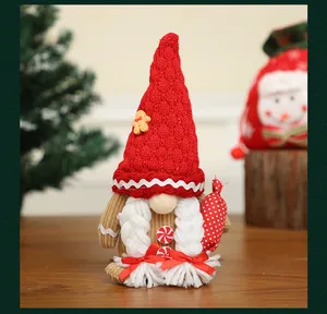 Dettaglio di uno gnomo natalizio in peluche con cappello rosso e decoro pan di zenzero