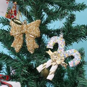 Sparkling gold sequined bow and colorful beaded candy cane ornaments on a green Christmas tree