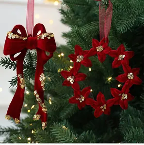 Close-up of red velvet Christmas ornaments with gold sequins on a tree branch.