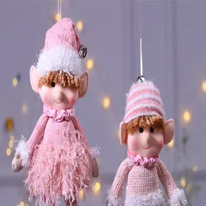 Vue détaillée de deux adorables elfes de Noël en peluche rose avec bonnets tricotés et cloches.