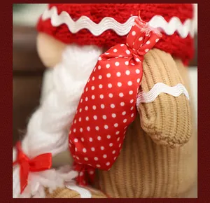 Dettaglio macro del cappello lavorato a maglia e della caramella a pois rossi sullo gnomo di Natale