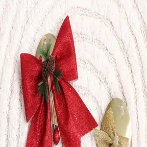 Detail van een rode glitter kerststrik met dennenappels en naalden voor doe-het-zelf decor.