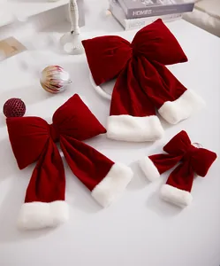 Close-up detail showing a set of three red velvet Christmas bows with plush white faux fur trim