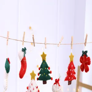 Close-up of handmade felt Christmas ornaments including stockings and trees on twine