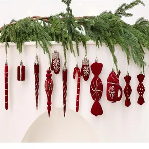 Nahaufnahme von weinroten beflockten Weihnachtsschmuck-Anhängern mit Glitzerdetails an Girlande
