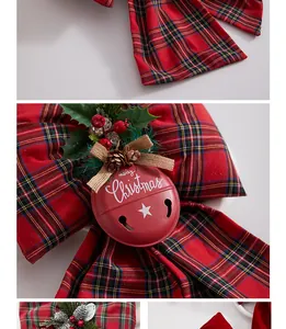 Macro detail view of a red plaid Christmas bow featuring a Merry Christmas bell ornament.