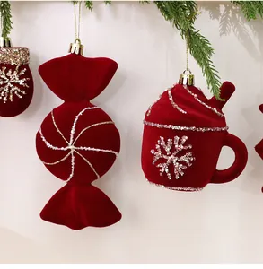 Nahaufnahme von roten beflockten Weihnachtsanhängern in Süßigkeiten- und Tassenform.