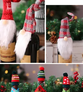 Detalle de fundas navideñas para botellas de vino con gnomos y gorros de punto