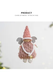 Détail d'un ange de Noël en peluche rose avec des ailes argentées et une cloche.