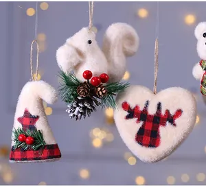 Dettaglio di decorazioni natalizie in peluche color crema con motivi a quadri rossi e pigne.