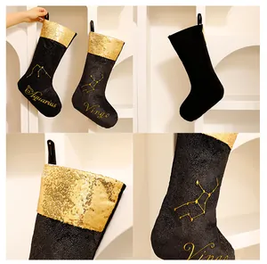 Detailansicht von schwarz-goldenen Pailletten-Weihnachtssocken mit feiner Sternzeichen-Stickerei.