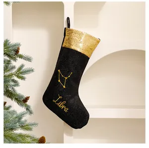 Detail einer schwarzen Weihnachtssocke mit Waage-Sternbild-Stickerei und Goldpailletten