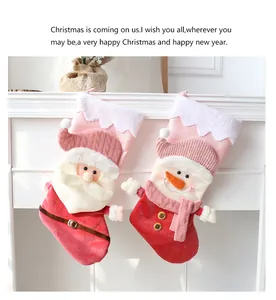 Close-up of plush Santa and Snowman Christmas stockings hanging on white mantel.
