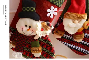 Detailed close-up of Santa and snowman plush ornaments on festive Christmas stockings
