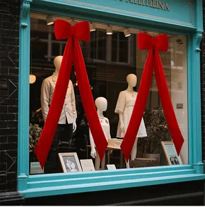Grand nœud en velours rouge avec de longs rubans pour la décoration de vitrine de Noël