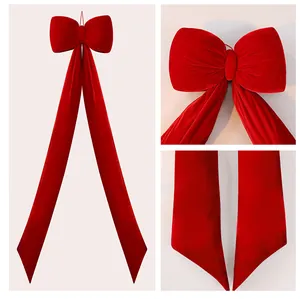 Vue détaillée du nœud de Noël en velours rouge de luxe montrant la texture et couture.