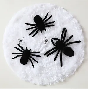 Détail de petites et grandes araignées noires en peluche pour Halloween sur un fond de toile blanche