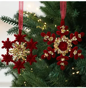 Detail view of red flocked snowflake ornaments with gold sequins on a Christmas tree