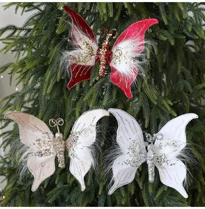 Detaillierte Textur von Weihnachts-Schmetterlingsornamenten mit Pailletten auf Tannenzweigen.
