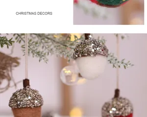 Détails de glands en feutre faits main avec des capuchons scintillants sur un sapin