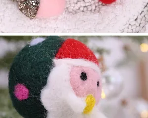 Gros plan d'une mignonne boule en feutre de laine Père Noël faite à la main