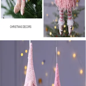 Vue détaillée d'ornements de gnomes de Noël en tricot rose avec des lumières de fête bokeh.
