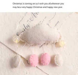 Vue détaillée d'un nuage en feutre blanc fait main avec des gouttes roses