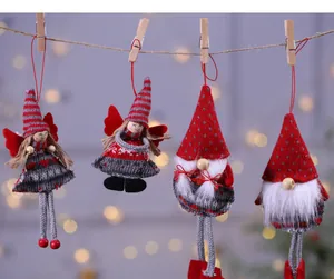 Cuatro adornos navideños de punto con ángeles y gnomos colgados de una cuerda de cáñamo.