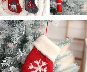 Nahaufnahme eines roten Weihnachtssocken-Anhängers aus Filz mit Schneeflocke am Baum