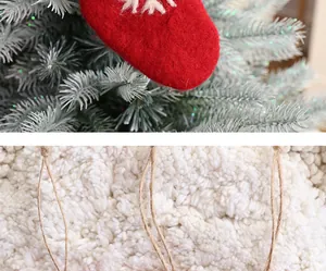 Nahaufnahme von rotem Filz-Weihnachtsschmuck und weißem, flauschigem Plüschmaterial