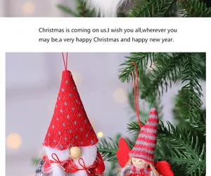 Detalle de adornos hechos a mano de gnomos y ángeles de Navidad en un árbol verde
