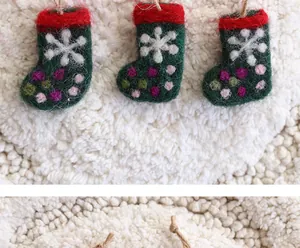 Detailansicht handgefertigter grüner Filz-Weihnachtssocken mit Schneeflockenmuster