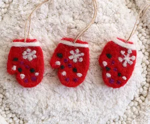 Detailansicht von roten Filz-Weihnachtshandschuh-Anhängern auf weißem Hintergrund