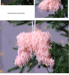 Soft pink fuzzy Christmas tree ornament hanging on festive evergreen branch