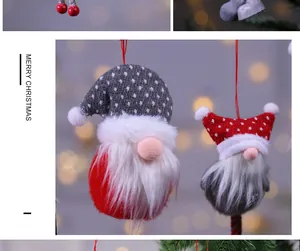 Primer plano detallado de adorables gnomos navideños de felpa con gorros rojos y grises